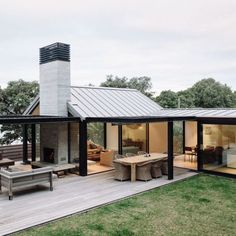 a modern house with glass walls and wood decking