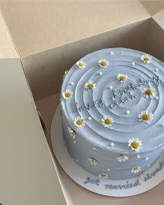 a cake in a box with daisies on it