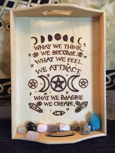 a wooden box with some rocks and stones in it that says, what we think we become when we feel