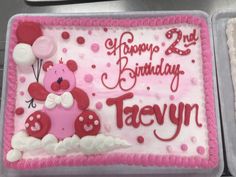 a pink and white birthday cake with teddy bear on it