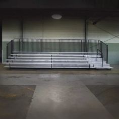 an empty bleachers with white seats and railings