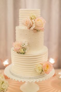 a white wedding cake with flowers on top