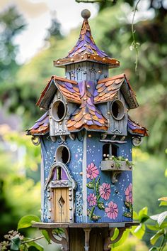 a blue birdhouse sitting on top of a tree branch