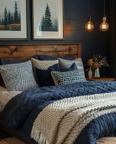 a bed with blue and white comforter in a bedroom next to two pictures on the wall