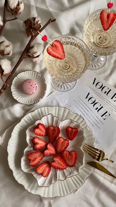 there are strawberries on the plate next to two wine glasses and a paper napkin