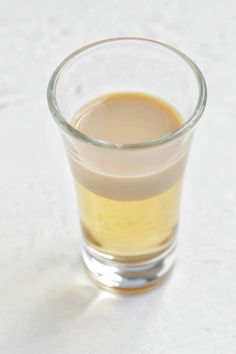 a glass filled with liquid sitting on top of a table