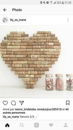 a heart made out of wine corks on top of a white shelf next to jars