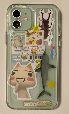 an iphone case with various stickers on the front and back of it, including a shark