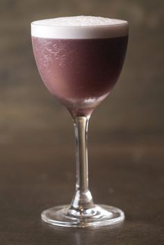 a glass filled with liquid sitting on top of a table