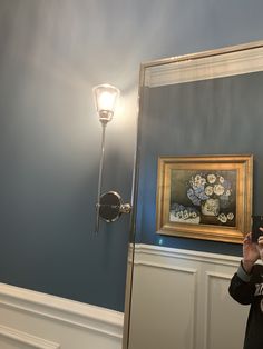 a woman taking a selfie in front of a mirror with a light on it