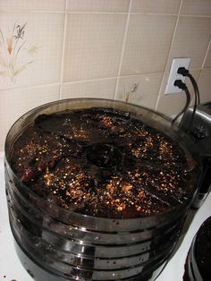 a cake sitting on top of a stove covered in chocolate