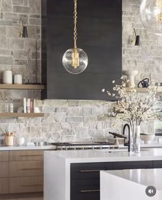 a kitchen with an island and hanging lights