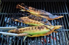 corn on the cob being grilled with tongs