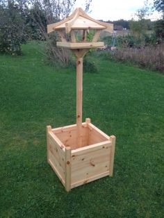 a wooden planter sitting on top of a lush green field