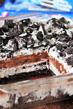 a cake with oreo cookies and cream in it on top of a wooden table