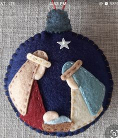 a felt ornament with an image of two baby's in the crib