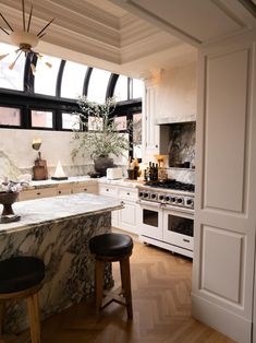 a kitchen with marble counter tops and an island in front of the stove top oven