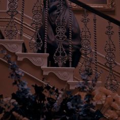 an ornate stair case next to a bunch of flowers