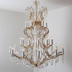 a chandelier hanging from the ceiling in a room with white walls and flooring