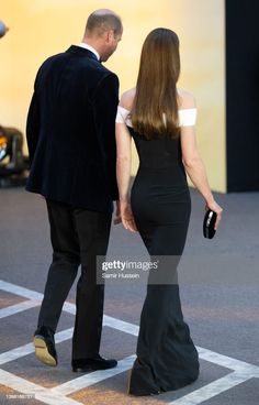 a man and woman walking down the street in formal wear stock photo getty images