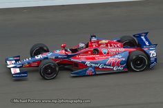 a red and blue race car driving on a track