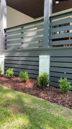 the side of a house with landscaping in front of it and an advertise that reads