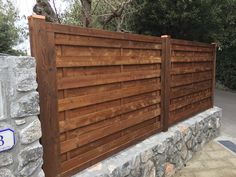 a wooden fence next to a stone wall