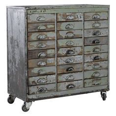 an old metal cabinet with lots of drawers on it's wheels and knobs