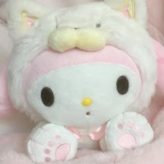 a hello kitty stuffed animal sitting on top of a pink blanket