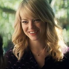 a woman with blonde hair smiling at someone