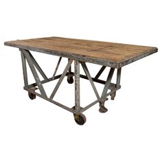 an old wooden table with wheels on it