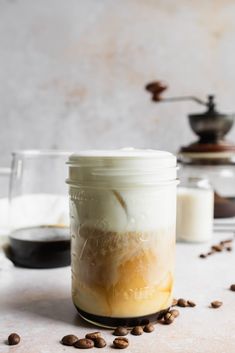 a glass jar filled with liquid next to coffee beans