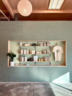 a shelf with some items on it in front of a green tiled wall and ceiling