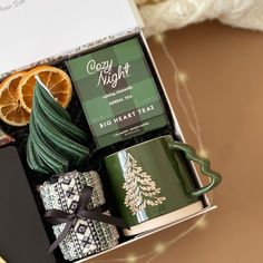 an open gift box containing coffee, orange slices and tea with a christmas tree decoration