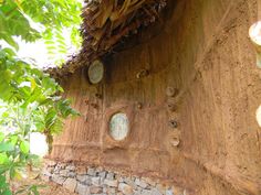 there are many round holes in the side of this building that is made out of rocks