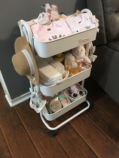 a baby changing table with several items in it on a wooden floor next to a couch