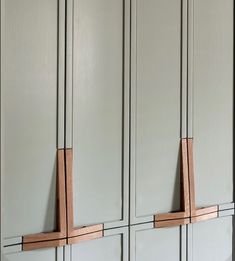 two wooden pegs are attached to the side of some cupboards in a kitchen