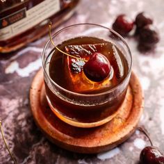 a small glass filled with liquid and cherries