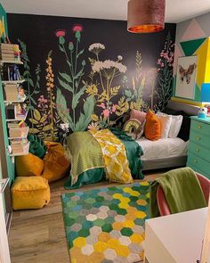 a bedroom decorated in bright colors with flowers painted on the wall and rugs covering the floor