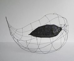 a wire sculpture with a leaf on it