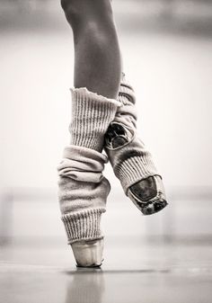 black and white photograph of someone's feet with socks wrapped around their ankles on the dance floor