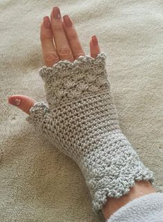 a woman's hand with crocheted fingerless gloves