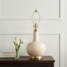 a white vase sitting on top of a wooden table