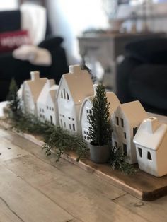 a wooden table topped with small white houses