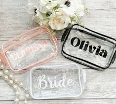 three clear bags with bride and groom's names on them sitting next to flowers