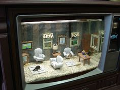 an old fashioned television with miniature furniture on display