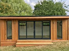 a small wooden building sitting on top of a lush green field