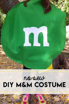 a girl wearing a green m & m costume with the words, diy msm costume