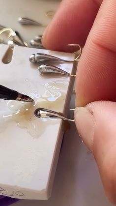 a pair of scissors are being used to cut through the wire on a piece of white paper