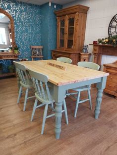 a dining room table with six chairs and a clock on the wall